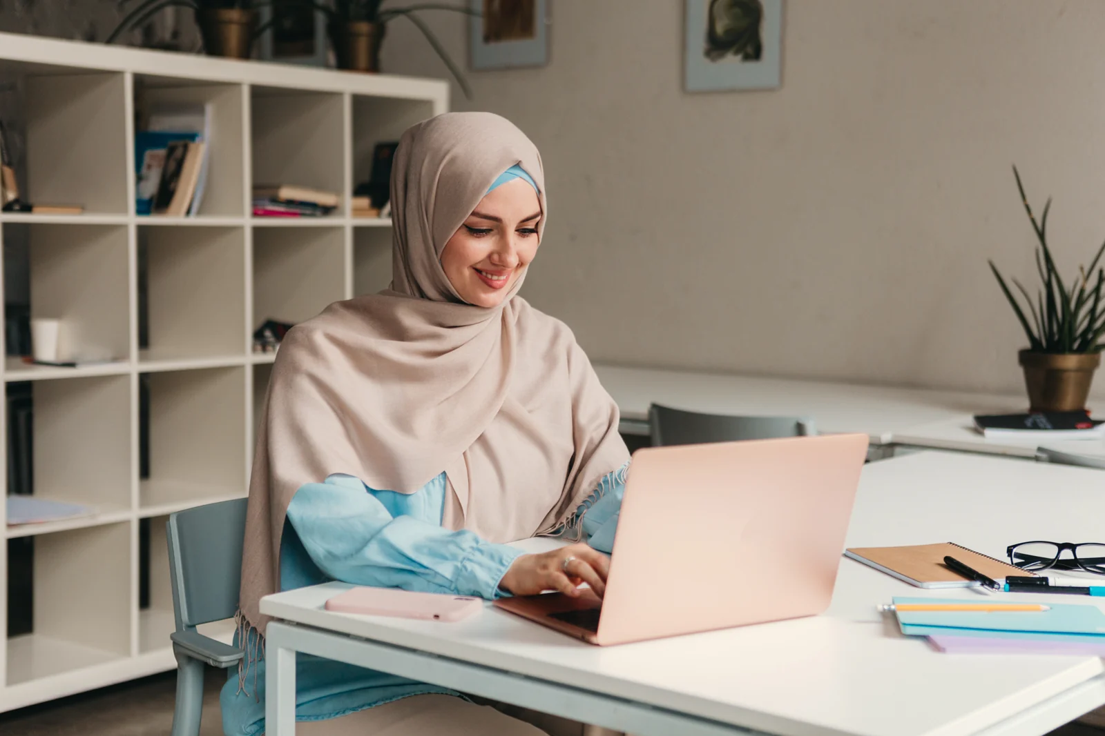 A teacher in hijab taking a lesson on her laptop